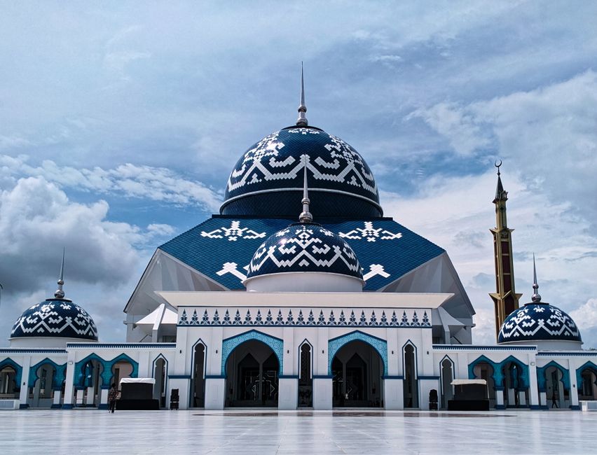 Explore this beautiful Islamic mosque with intricate blue and white designs under a clear sky. (photo by Kopi Hitam Mantap on Pexels)