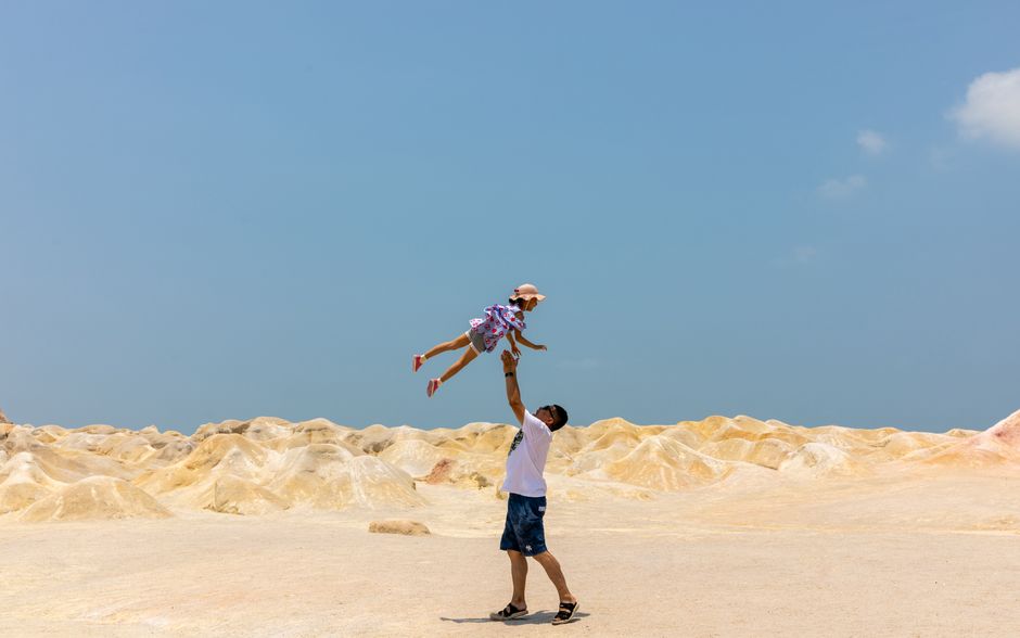 A joyful moment between father and child in a sunny desert landscape. (photo by 李进 on Pexels)