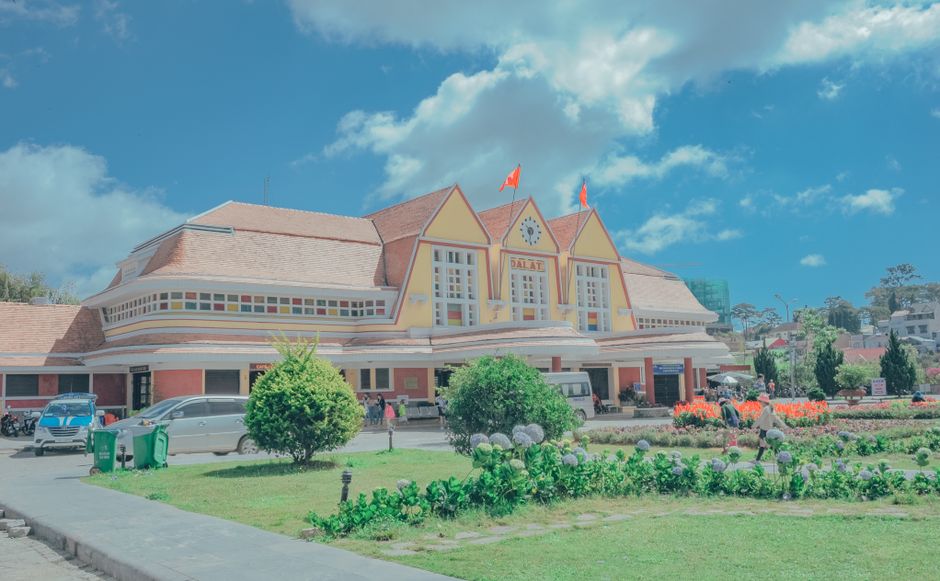 Historic Dalat Railway Station with vibrant gardens under a blue sky. (photo by Min An on Pexels)