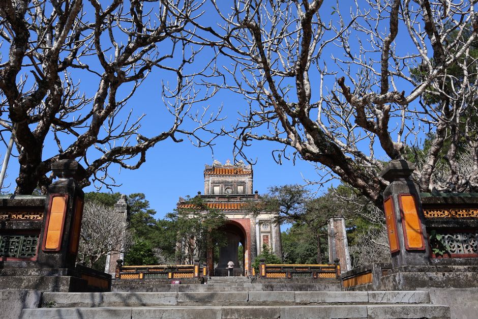 Hanoi to Hue: Train, Bus and Flight Guide (2026) The majestic entrance of Minh Mang Tomb framed by bare trees in Hue, Vietnam. (photo by Minh Lê on Pexels)