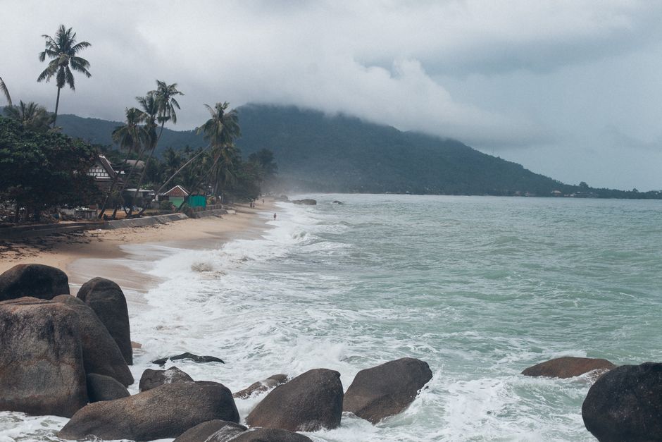 Serene view of a tropical beach in Koh Samui, Thailand, with crashing waves and lush greenery. (photo by Elina Sazonova on Pexels)