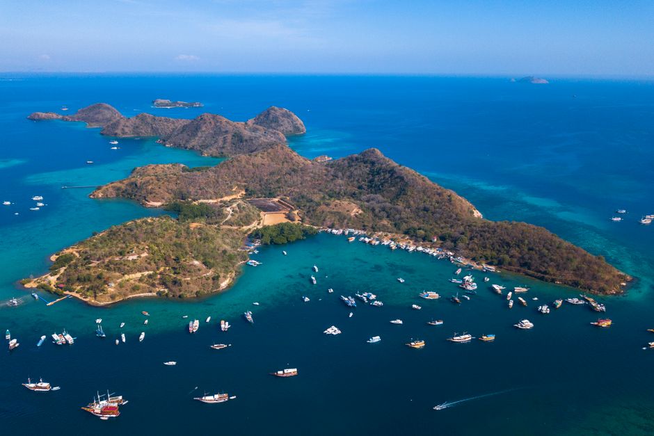 Stunning aerial photograph of Labuan Bajo islands in East Nusa Tenggara, showing vibrant blue waters and numerous boats. (photo by kevin yung on Pexels)