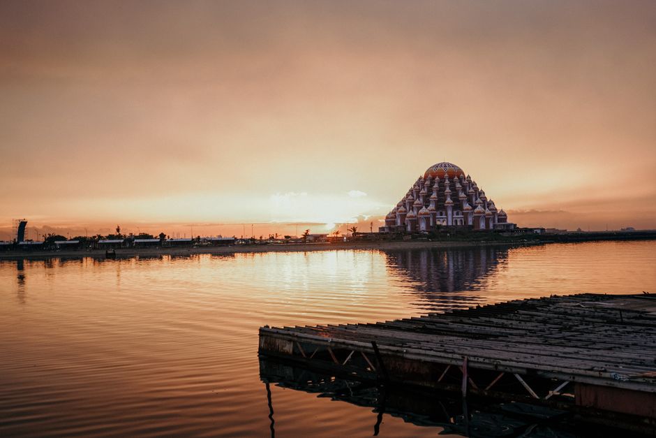 Capture of Makassar's Floating Mosque at sunset reflecting over calm waters. (photo by wsdidin on Pexels)